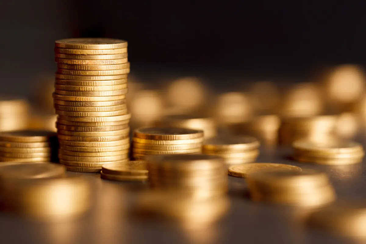 Stacks of gold coins on a dark surface
