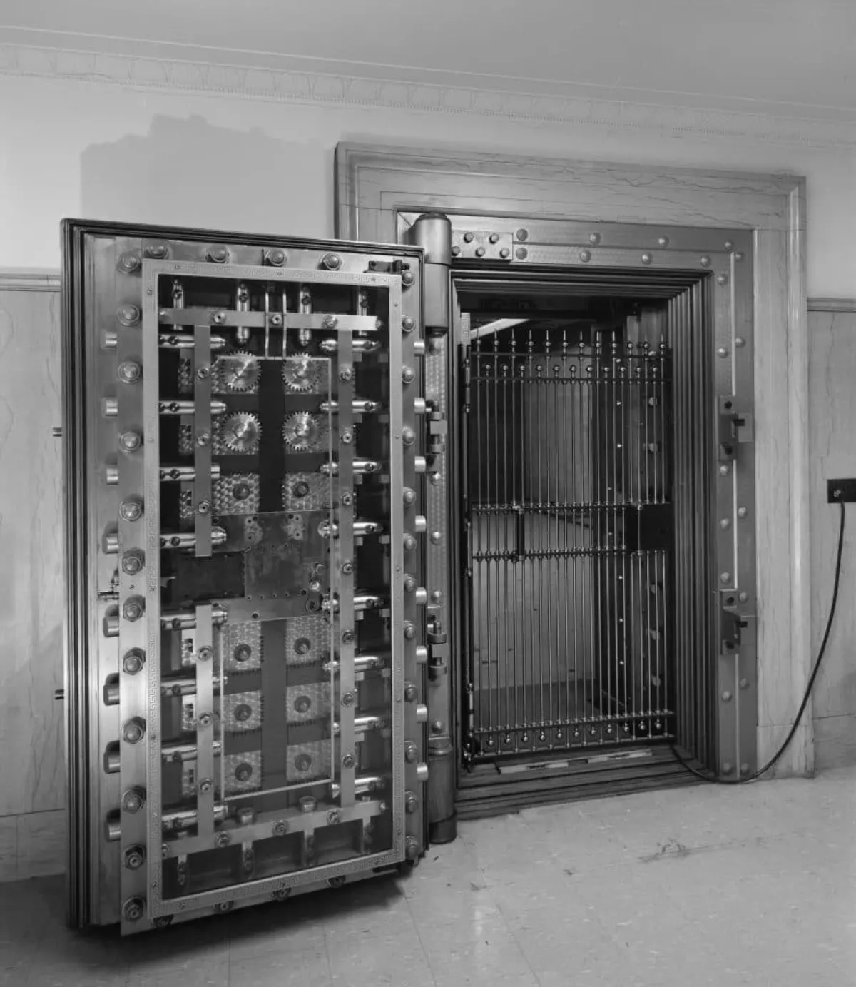 Open steel bank vault door showing its locking mechanism